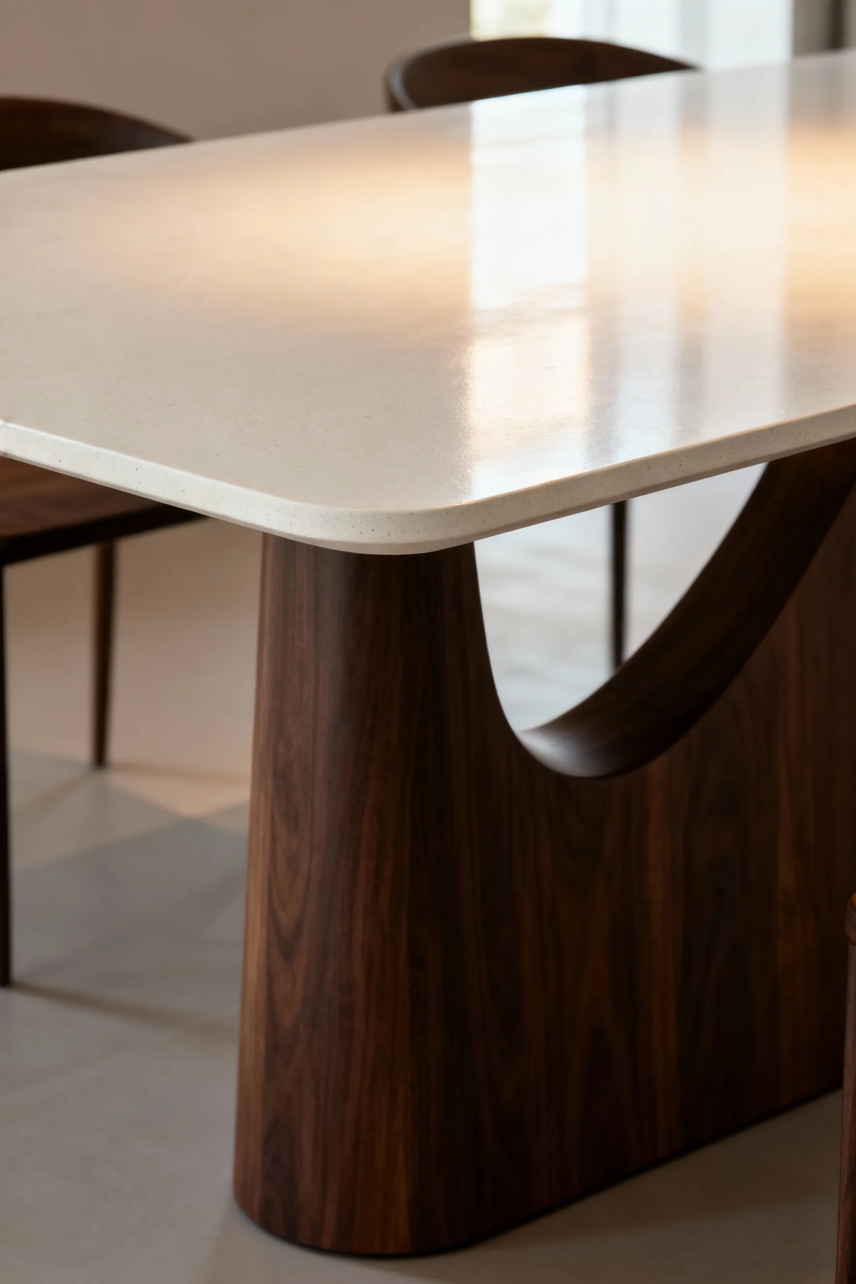 Modern dining table with a walnut base and UHPC top, showcasing ergonomic design and sophisticated material juxtaposition in a minimalist setting. Focus on experiential design.