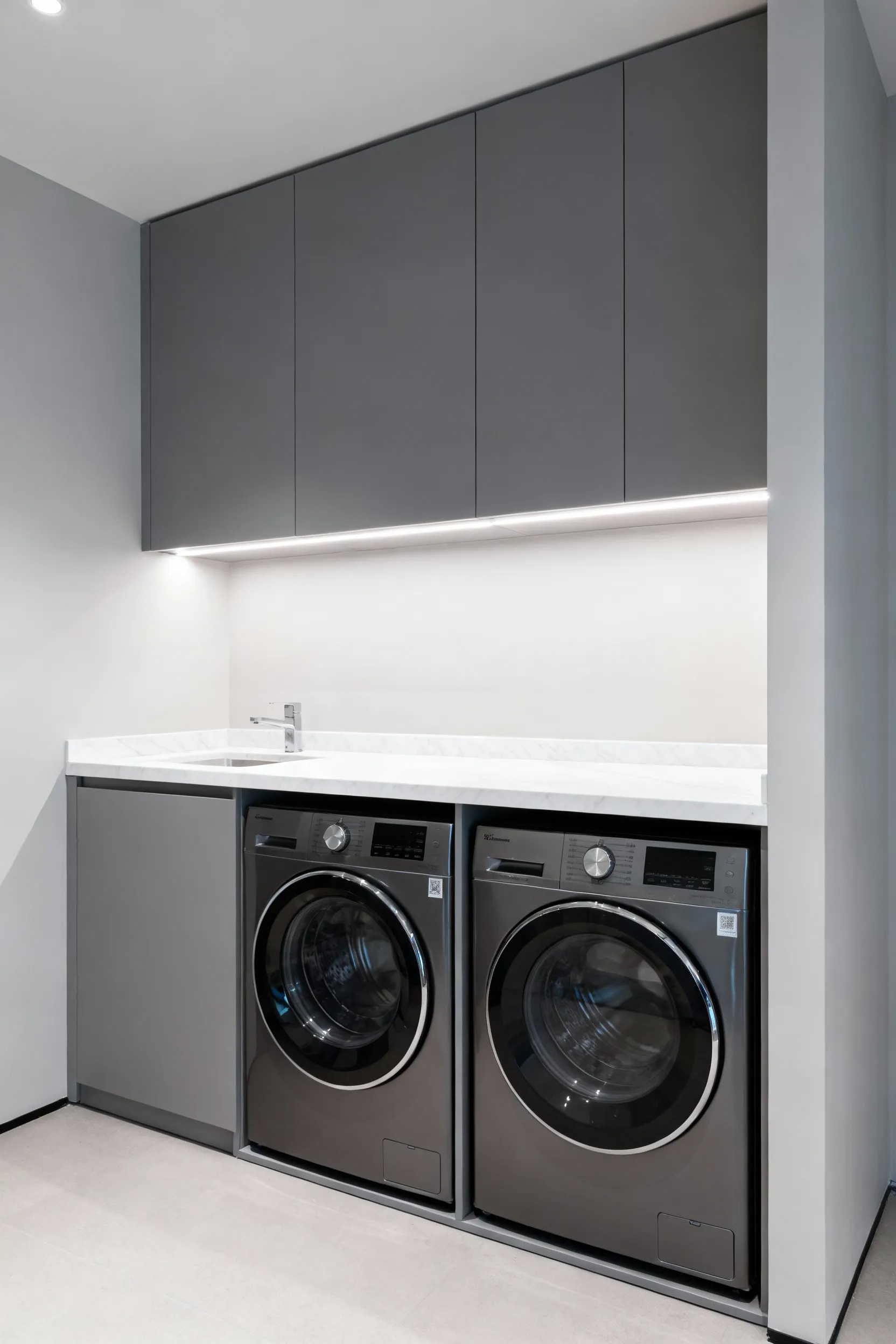 High-end laundry room with concealed washing machine and dryer integrated into custom, seamless modern cabinetry, enhancing architectural flow.