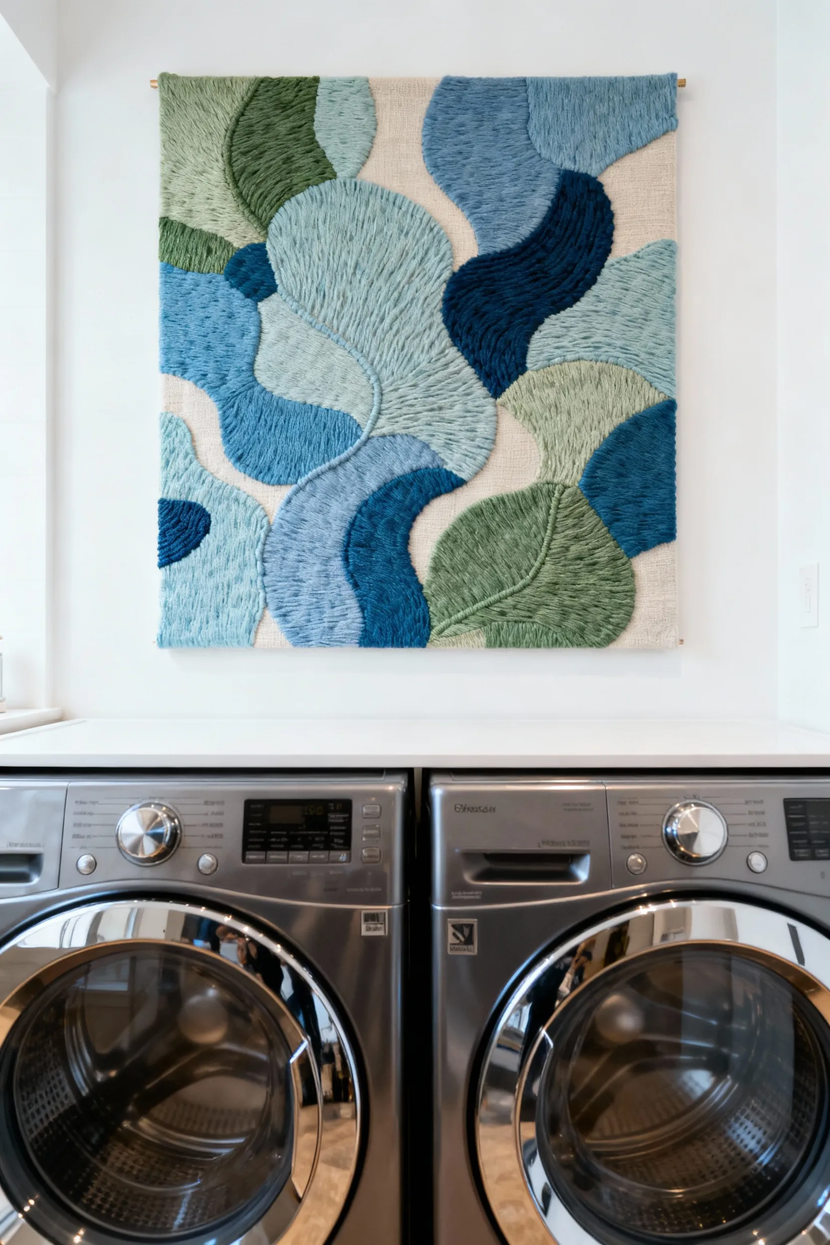 A close-up view of personalized textile art with abstract patterns and moisture-resistant fabric, mounted above modern laundry machines, enhancing a serene laundry room.