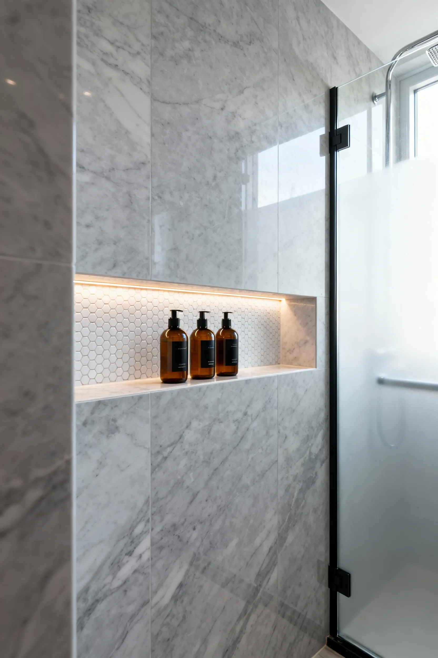 A sleek, compact shower featuring a recessed wall niche lined with mosaic tile holding toiletries, demonstrating zero-footprint storage as an alternative to hanging shower caddies.