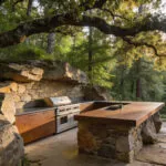 High-end outdoor kitchen featuring natural stone and Dekton materials seamlessly integrated into a forest landscape.