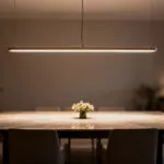Elegant linear pendant light perfectly illuminating a rectangular dining table in a modern dining room